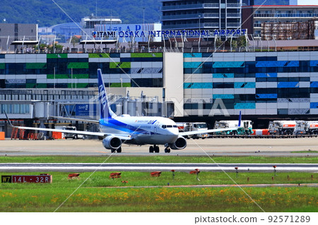 Osaka International Airport, a passenger plane taking off and landing 92571289