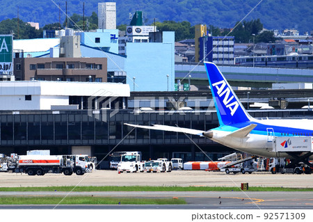 Osaka International Airport, a passenger plane taking off and landing 92571309