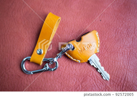 Genuine keychain leather crafts working on red leather background Genuine keychain leather crafts working on red leather background 92572005