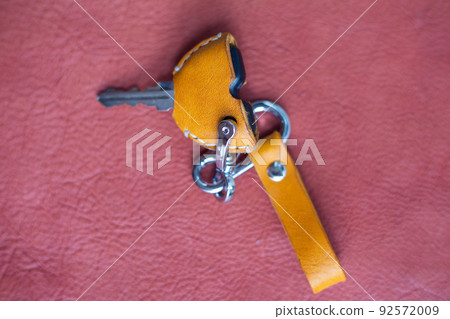 Genuine keychain leather crafts working on red leather background Genuine keychain leather crafts working on red leather background 92572009