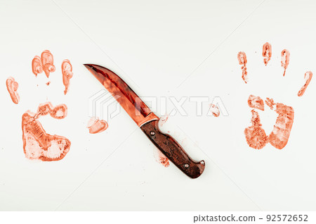 Bloody knife and hand prints in blood on a white table. Bloody knife and hand prints in blood on a white table. 92572652