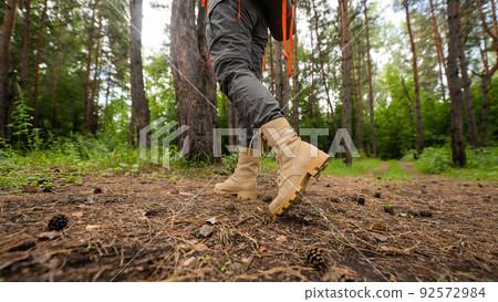 The woman is engaged in hiking in a pine forest. close-up of legs, 92572984