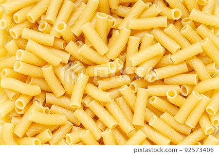 Raw pasta. Food background. An ingredient for traditional Italian food. Closeup Raw pasta. Food background. An ingredient for traditional Italian food. Closeup 92573406