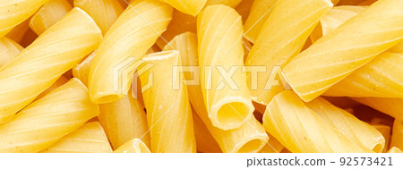 Raw ziti pasta. Food background. An ingredient for traditional Italian food. Closeup Raw ziti pasta. Food background. An ingredient for traditional Italian food. Closeup 92573421
