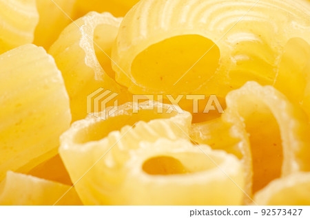 Raw ziti pasta. Food background. An ingredient for traditional Italian food. Closeup Raw ziti pasta. Food background. An ingredient for traditional Italian food. Closeup 92573427