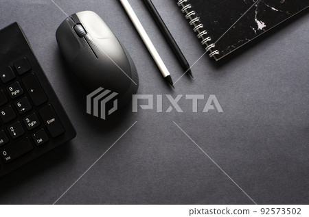 Computer keyboard and mouse on a black background. Copy space. Flat top view. 92573502