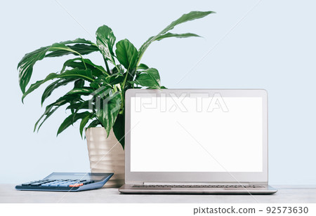 Front view of the laptop with mockup screen on the desk. calculator 92573630