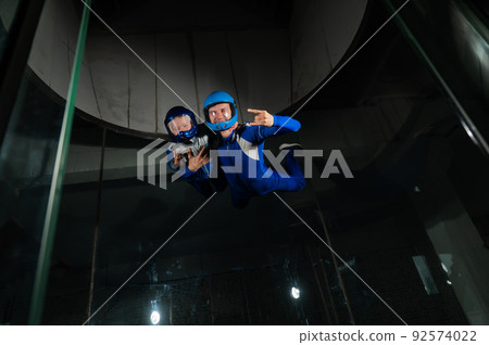 A man teaches a boy to fly in a wind tunnel. Lack of gravity. A man teaches a boy to fly in a wind tunnel. Lack of gravity. 92574022