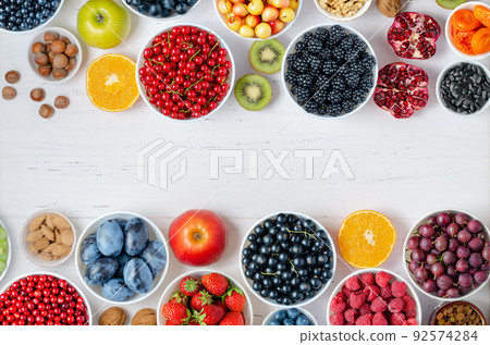 Fresh berries, fruits, nuts on a white wooden background. The concept of healthy eating. Food contains vitamins and trace elements. Copy space. Fresh berries, fruits, nuts on a white wooden background. The concept of healthy eating. Food contains vitamins and trace elements. Copy space. 92574284