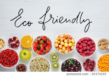Fresh berries, fruits, nuts on a white wooden background. The concept of healthy eating. Food contains vitamins and trace elements. Eco friendly - handwritten inscription. Fresh berries, fruits, nuts on a white wooden background. The concept of healthy eating. Food contains vitamins and trace elements. Eco friendly - handwritten inscription. 92574285
