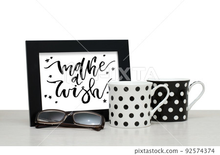 Make a wish. Handwritten inscription in the frame. Modern calligraphy. Coffee Cup, glasses Make a wish. Handwritten inscription in the frame. Modern calligraphy. Coffee Cup, glasses 92574374