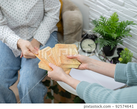 Psychologist uses metaphorical associative cards in a session with a patient. Close-up of female hands. Psychologist uses metaphorical associative cards in a session with a patient. Close-up of female hands. 92574641