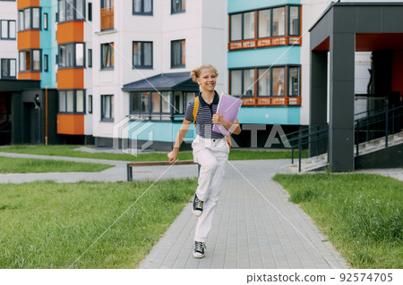 A happy student runs to school, hurries to classes, rejoices in the new academic year. Back to school A happy student runs to school, hurries to classes, rejoices in the new academic year. Back to school 92574705