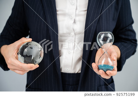 Business woman holding crystal globe and hourglass. Business woman holding crystal globe and hourglass. 92575199