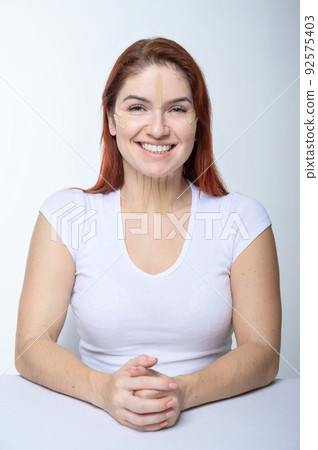 Portrait of a redhead woman with tapes on skin color face for rejuvenation. An alternative way to fight wrinkles. Portrait of a redhead woman with tapes on skin color face for rejuvenation. An alternative way to fight wrinkles. 92575403