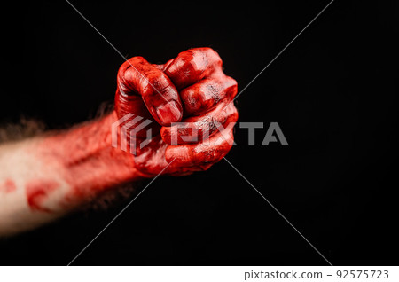 Bloody male fist on a black background. Copy space. Bloody male fist on a black background. Copy space. 92575723
