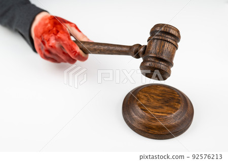 Female judge with bloody hands beats the gavel on a white background. Female judge with bloody hands beats the gavel on a white background. 92576213