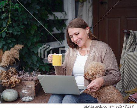 woman with laptop working outdoors in garden, home office concept. woman with laptop working outdoors in garden, home office concept. 92577157