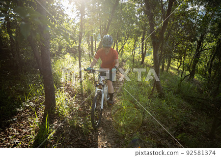 Mountain biking in summer forest Mountain biking in summer forest 92581374