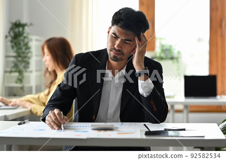 Serious businessman reading document, solving business problem. Emotional pressure, stress at work concept 92582534