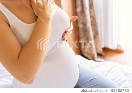 Breast test cancer pregnancy woman check. Happy young pregnant woman self exam. Breast self exam BSE, breast cancer awareness concept. 92582780