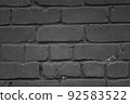 Brick wall close-up. The brick wall painted in black. Place for text. Empty space 92583522