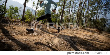 Woman trail runner running at sunrise tropical forest mountain peak Woman trail runner running at sunrise tropical forest mountain peak 92584105