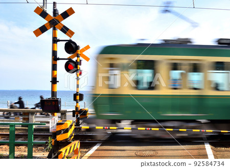 Enoden running at the railroad crossing on the Koshigoe coast 92584734