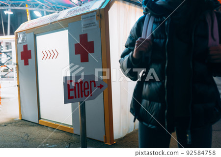 Woman in a medic mask is staying at disinfection tunnel Woman in a medic mask is staying at disinfection tunnel 92584758