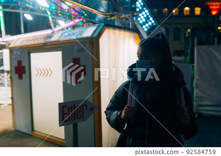 Woman in a medic mask is staying at disinfection tunnel 92584759