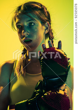 Motiovation for win. Young girl, MMA fighter in sports uniform isolated on yellow background. Concept of sport, competition, action, healthy lifestyle. 92585078