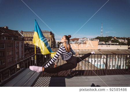 A young woman is doing twine on the roof of the house A young woman is doing twine on the roof of the house 92585486