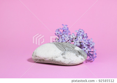 gray white stone as a podium, with lilac flowers on a pink background with hard shadows. Minimal empty cosmetic product presentation scene. Geometric eco podium. 92585512