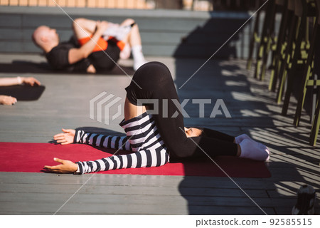 Yogi woman and diverse group of sporty people practicing yoga Yogi woman and diverse group of sporty people practicing yoga 92585515