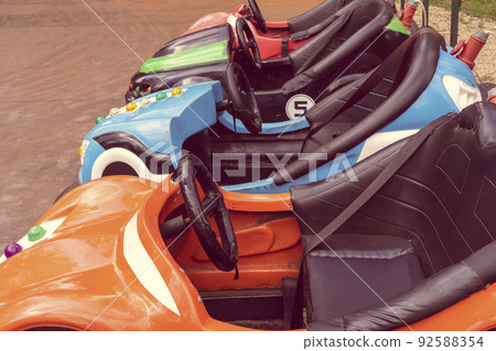 A row of dodgem cars are being charged at a power charging station 92588354