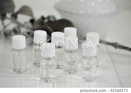 白色瓷磚上排列著小塑料瓶液體 白色瓷磚上排列著小塑料瓶液體 92588373