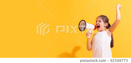 Emotional cute girl, kid shouting at megaphone isolated on bright yellow background. Concept of news, holidays, vacation, fashion, beauty, ad Emotional cute girl, kid shouting at megaphone isolated on bright yellow background. Concept of news, holidays, vacation, fashion, beauty, ad 92588773