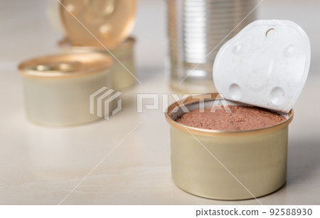 Several cans of cat food. One of them is open with a pate inside. Several cans of cat food. One of them is open with a pate inside. 92588930