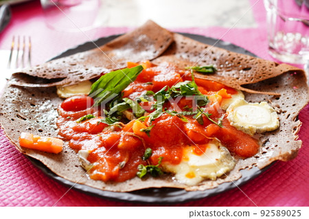French buckwheat crepe galette with fresh tomatoes, goat cheese and basil French buckwheat crepe galette with fresh tomatoes, goat cheese and basil 92589025