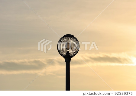 Silhouette of sunset sky and round streetlights Silhouette of sunset sky and round streetlights 92589375