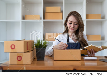 Successful woman entrepreneur with parcel boxes shopping online business at home Successful woman entrepreneur with parcel boxes shopping online business at home 92589508