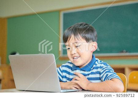 在筆記本電腦上在線學習的小學生 在筆記本電腦上在線學習的小學生 92589712