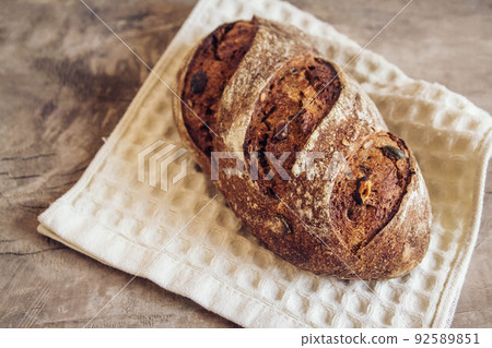 Brown fresh bread with seeds on old wood background. Top view, copy space 92589851
