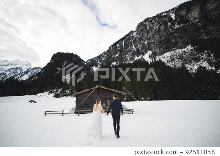 The couple, the bride and groom holding hands in the mountains The couple, the bride and groom holding hands in the mountains 92591038