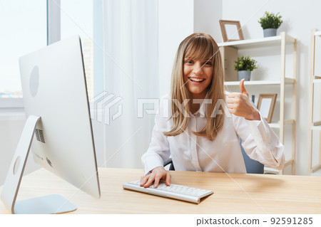 Happy enjoyed adorable blonde businesswoman worker freelancer look at camera show thumb up gesture in light modern office. Employee work on computer online enjoy successful career. Copy space Happy enjoyed adorable blonde businesswoman worker freelancer look at camera show thumb up gesture in light modern office. Employee work on computer online enjoy successful career. Copy space 92591285