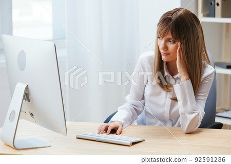 Focused adorable blonde businesswoman typing answer for client look at screen sitting at workplace in modern office. Concentrated employee work on computer online in support service. Copy space Focused adorable blonde businesswoman typing answer for client look at screen sitting at workplace in modern office. Concentrated employee work on computer online in support service. Copy space 92591286