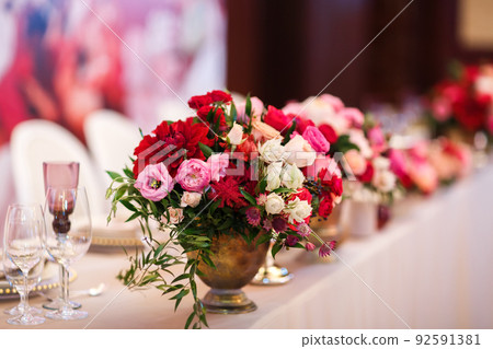Bouquets of flowers in vase on the wedding table Bouquets of flowers in vase on the wedding table 92591381