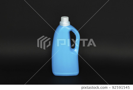 Blue plastic bottle with a grey cap isolated on black background for liquid detergent laundry or cleaning agent. Packaging template mockup. Blue plastic bottle with a grey cap isolated on black background for liquid detergent laundry or cleaning agent. Packaging template mockup. 92591545