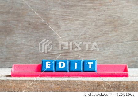Tile letter on red rack in word edit on wood background Tile letter on red rack in word edit on wood background 92591663
