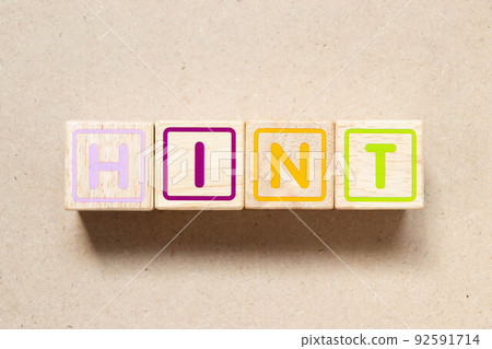 Color letter block in word hint on wood background 92591714